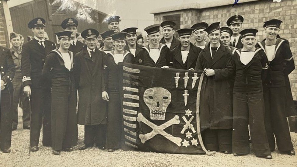 HMS Unbroken crew with their Jolly Rodgers.